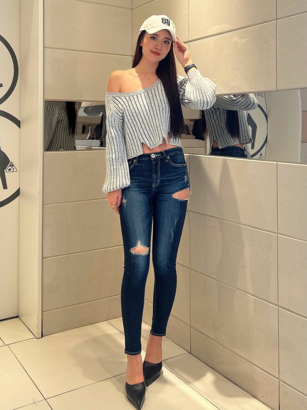 ブルー系のデニムパンツ、ブラック系のニット/セーター、ブラック系のパンプスを着用したレディースの冬コーディネートの1枚目の写真