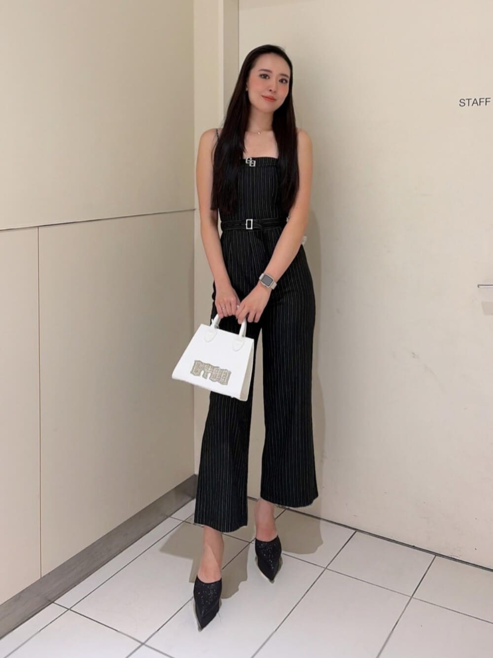 ブラック系のパンプス、ブラック系のつなぎ/オールインワン、ホワイト系のハンドバッグを着用したレディースの秋コーディネートの1枚目の写真