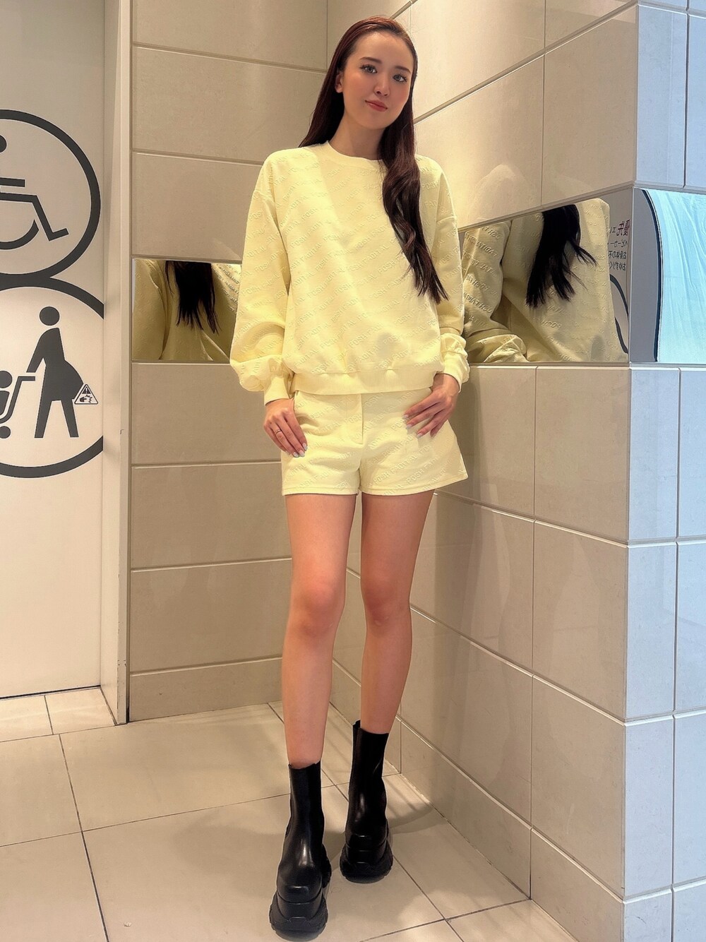 イエロー系のスウェット、イエロー系のその他パンツ、ブラック系のブーツを着用したレディースの冬コーディネートの1枚目の写真