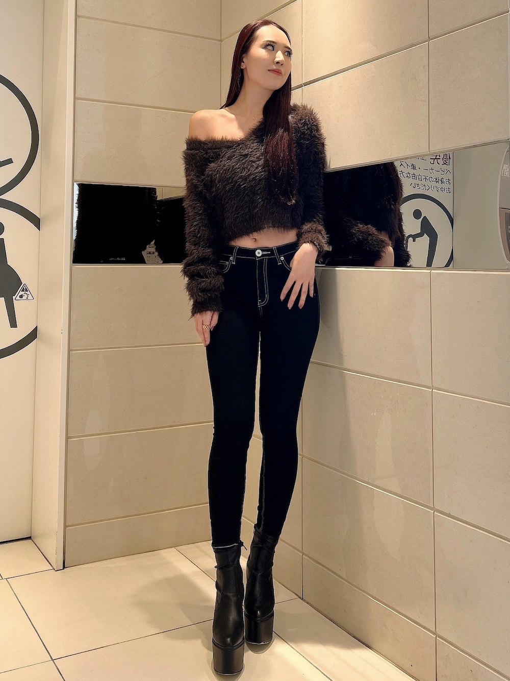 グレー系のニット/セーター、ブラック系のデニムパンツ、ブラック系のブーツを着用したレディースの冬コーディネートの1枚目の写真