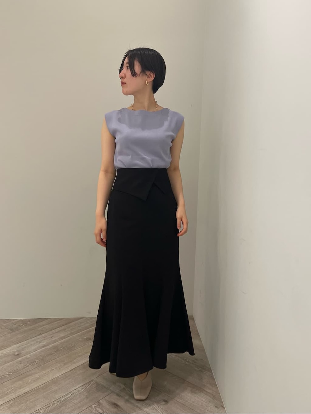 ホワイト系のパンプス、ブラック系のスカート、パープル系のニット/セーターを着用したレディースの夏コーディネートの1枚目の写真