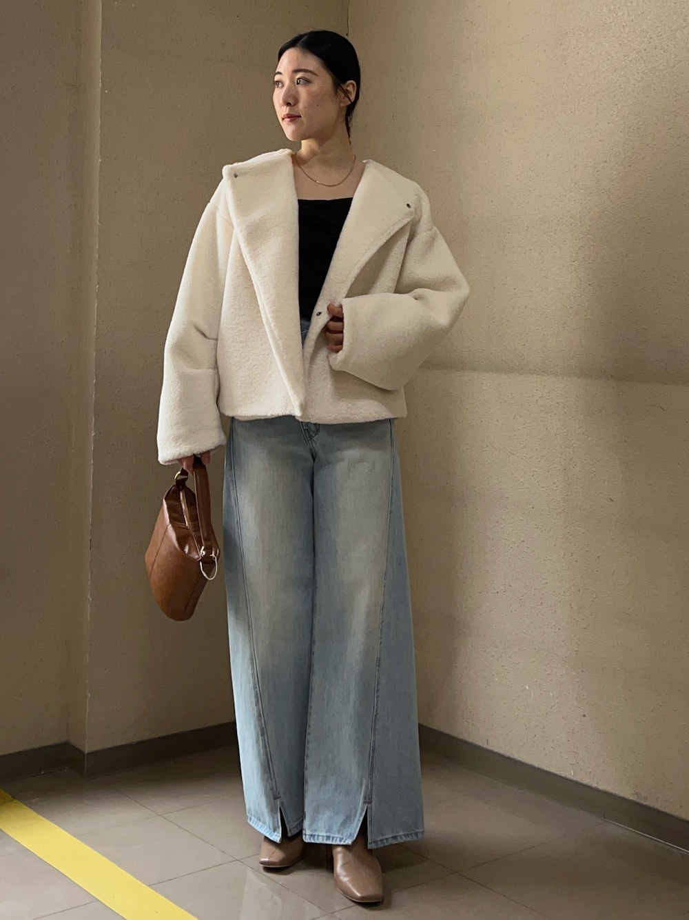 ブルー系のデニムパンツ、ホワイト系のブルゾン、ブラウン系のニット/セーターを着用したレディースの冬コーディネートの1枚目の写真