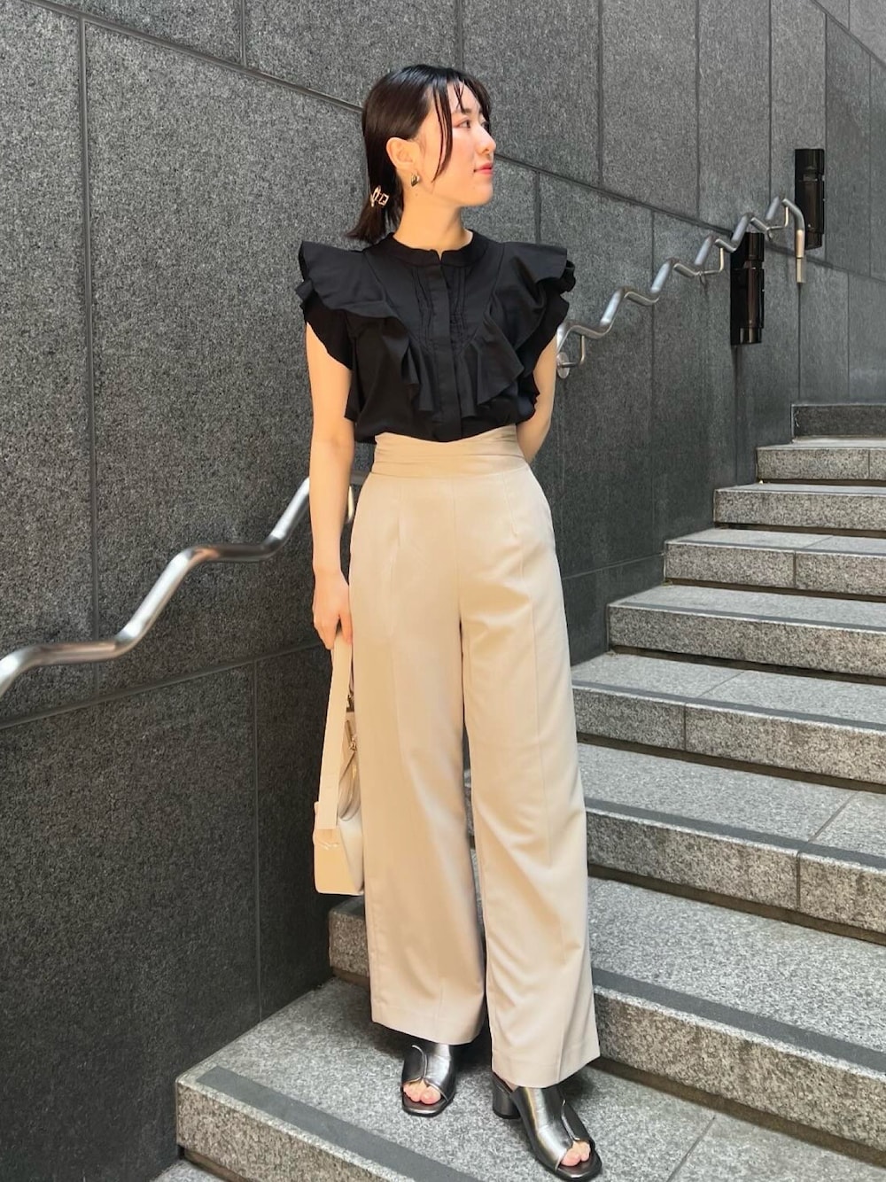 その他のサンダル、ベージュ系のハンドバッグ、ホワイト系のスラックスを着用したレディースの夏コーディネートの1枚目の写真