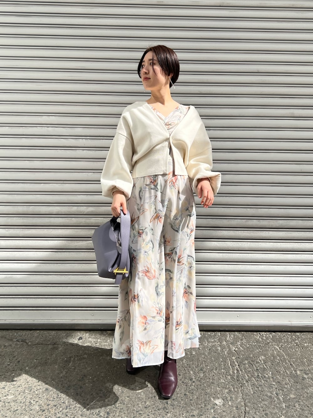 レッド系のブーツ、パープル系のハンドバッグ、ホワイト系のカーディガン/ボレロを着用したレディースの冬コーディネートの1枚目の写真