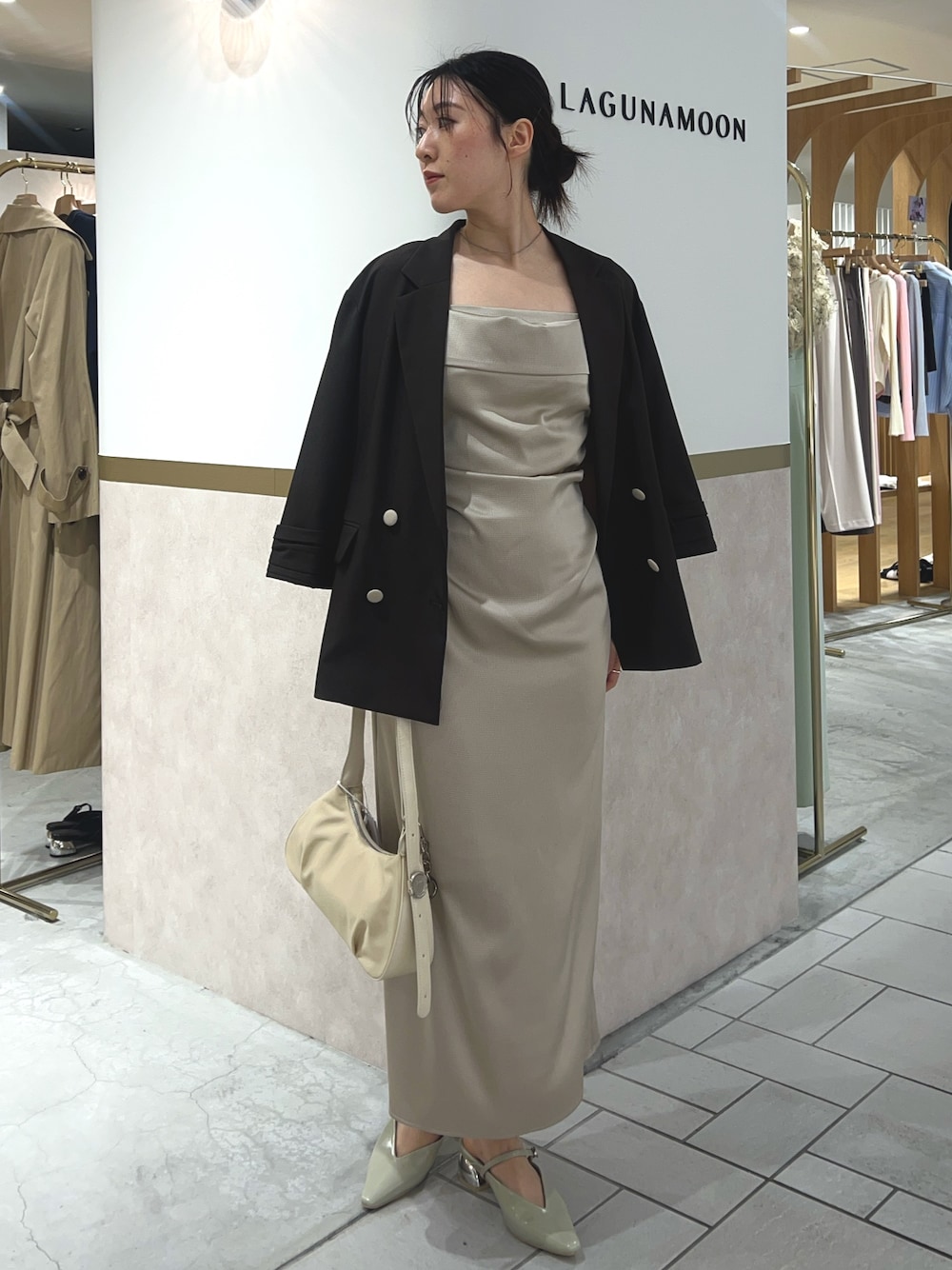 ベージュ系のワンピース、ブラウン系のテーラードジャケット、グリーン系のパンプスを着用したレディースの春コーディネートの1枚目の写真