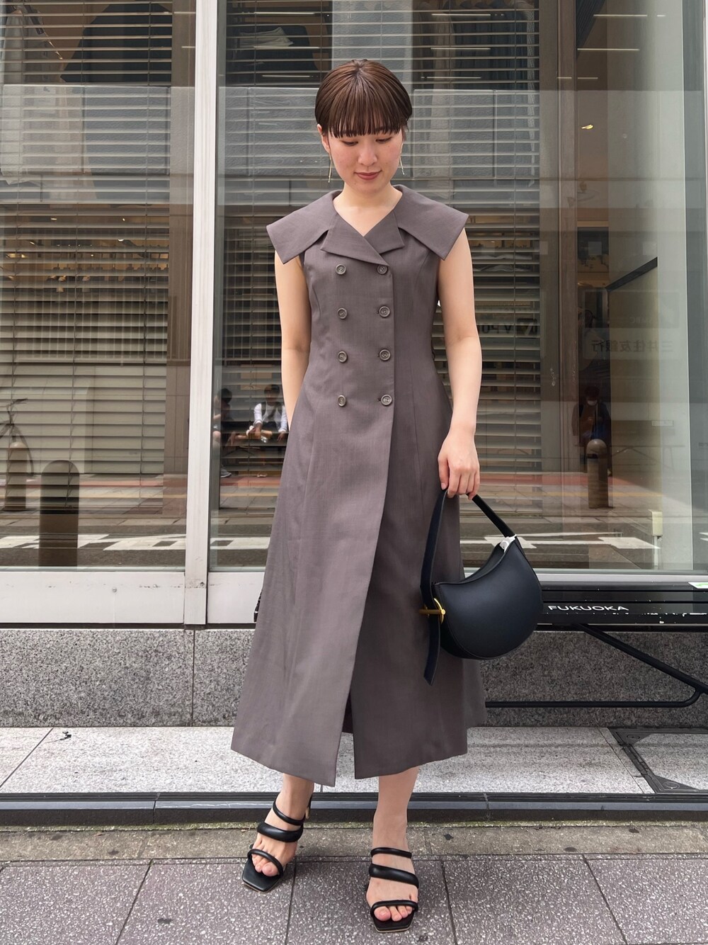 グレー系のワンピース、ブラック系のサンダル、ブラック系のハンドバッグを着用したレディースの夏コーディネートの1枚目の写真