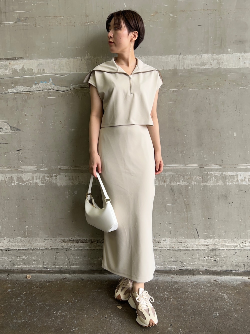 ホワイト系のハンドバッグ、ホワイト系のTシャツ/カットソー、ホワイト系のスカートを着用したレディースの夏コーディネートの1枚目の写真