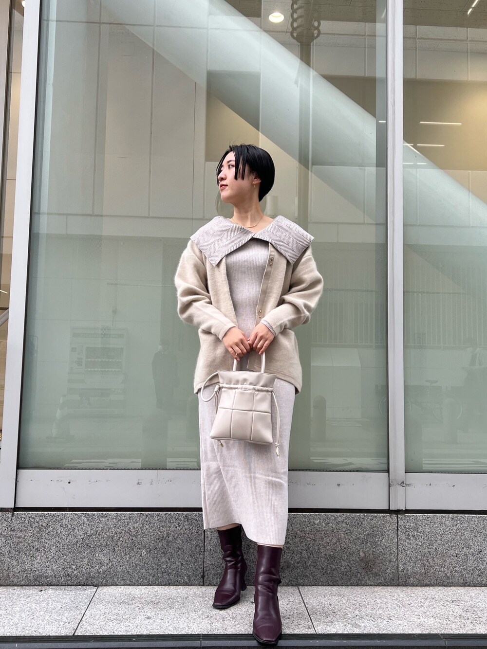 ホワイト系のワンピース、ホワイト系のカーディガン/ボレロ、レッド系のブーツを着用したレディースの冬コーディネートの1枚目の写真