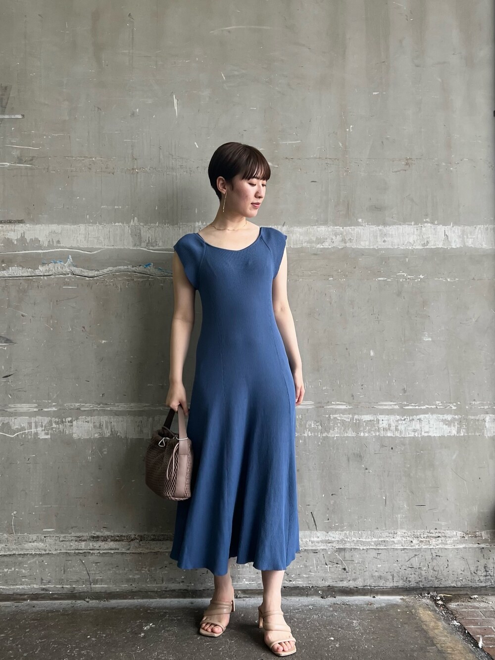 ホワイト系のハンドバッグ、ブルー系のワンピース、ベージュ系のサンダルを着用したレディースの夏コーディネートの1枚目の写真