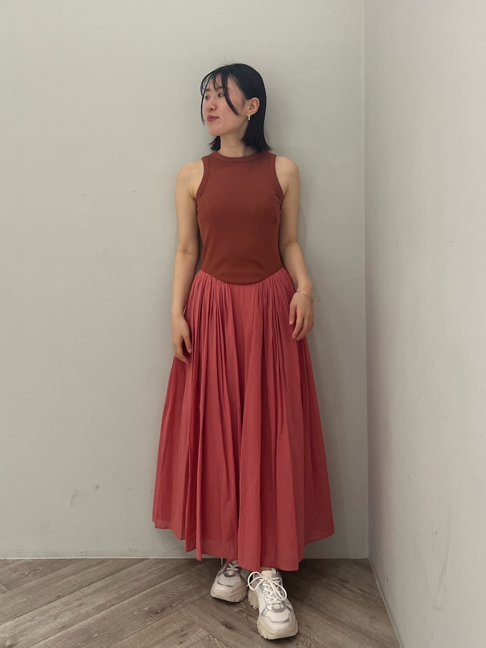 ピンク系のワンピース、ホワイト系のスニーカーを着用したレディースの夏コーディネートの1枚目の写真