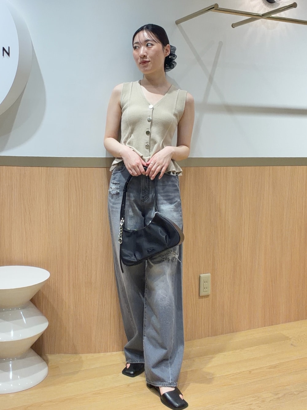 ベージュ系のニット/セーター、グレー系のデニムパンツ、ブラック系のサンダルを着用したレディースの春コーディネートの1枚目の写真