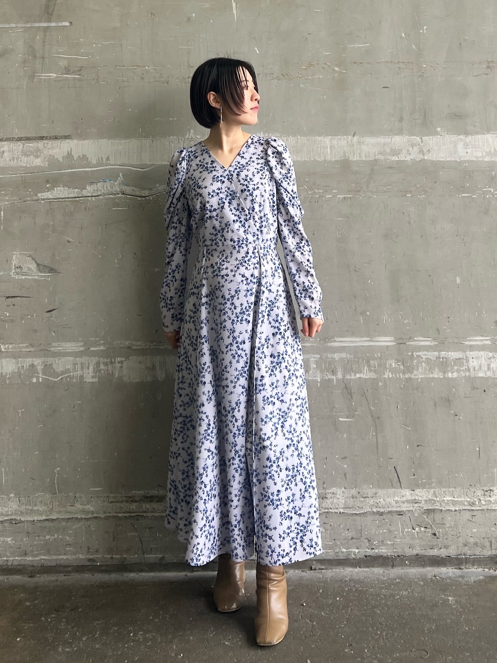 ベージュ系のブーツ、パープル系のワンピースを着用したレディースの冬コーディネートの1枚目の写真