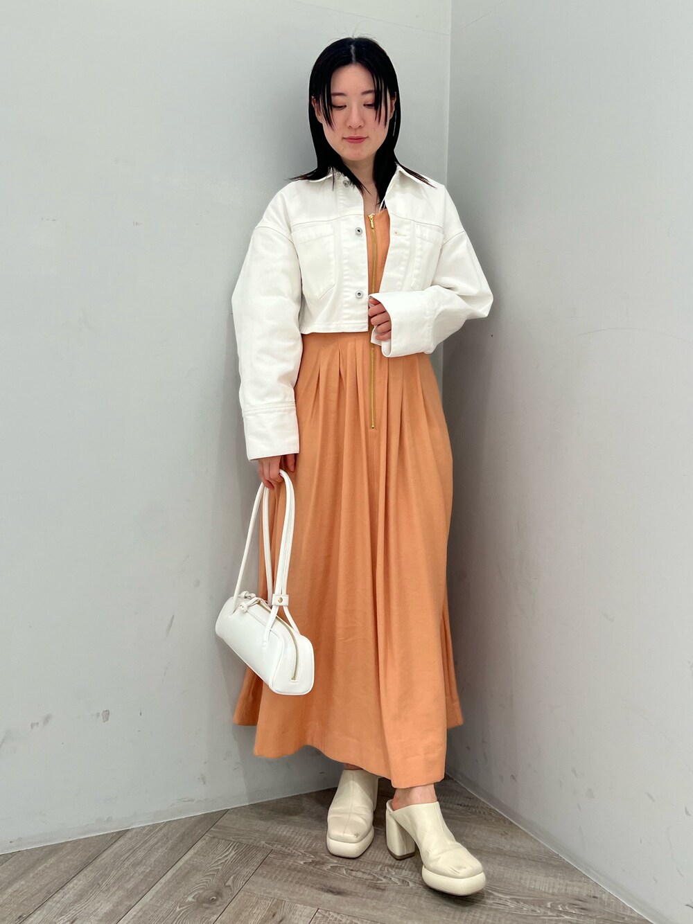 ホワイト系のサンダル、オレンジ系のワンピース、ホワイト系のデニムジャケットを着用したレディースの春コーディネートの1枚目の写真