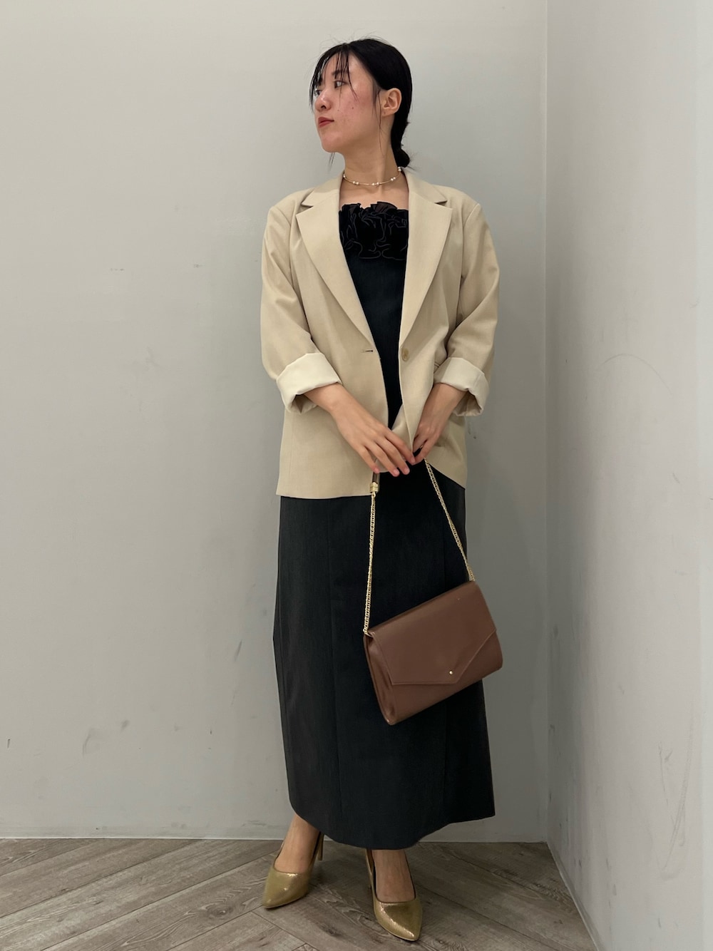 ゴールド系のパンプス、グレー系のドレス、ベージュ系のテーラードジャケットを着用したレディースの秋コーディネートの1枚目の写真