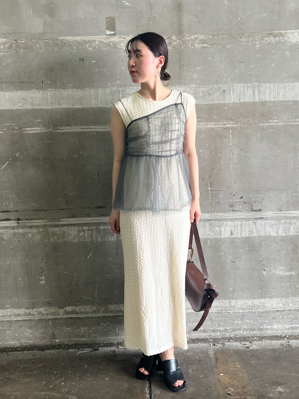 ブラック系のサンダル、ホワイト系のワンピースを着用したレディースの夏コーディネートの1枚目の写真