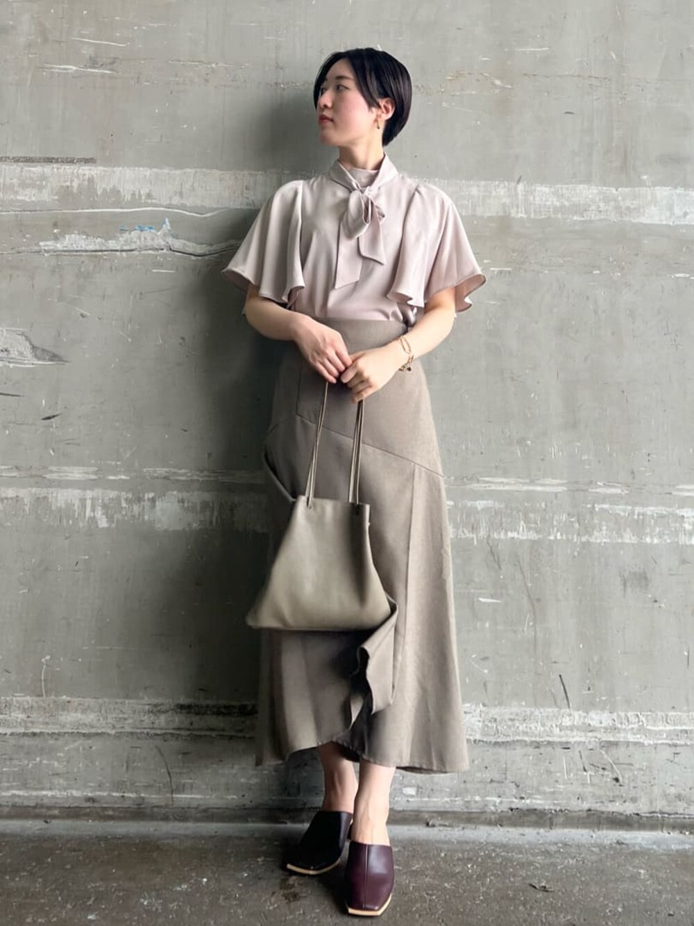 ベージュ系のハンドバッグ、レッド系のサンダル、ベージュ系のスカートを着用したレディースの夏コーディネートの1枚目の写真