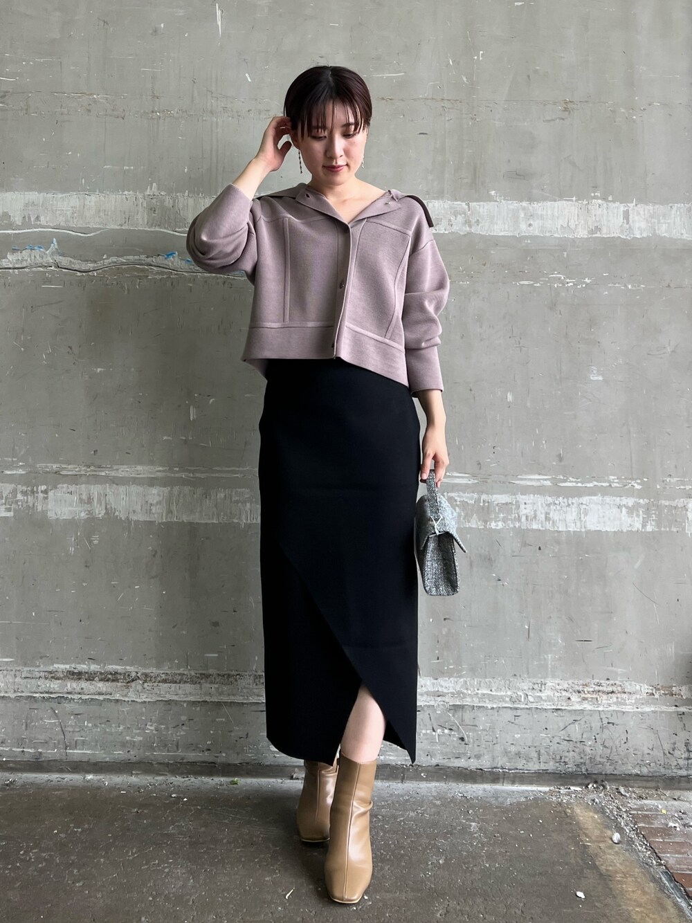 ベージュ系のブーツ、ブラック系のスカート、ベージュ系のカーディガン/ボレロを着用したレディースの秋コーディネートの1枚目の写真