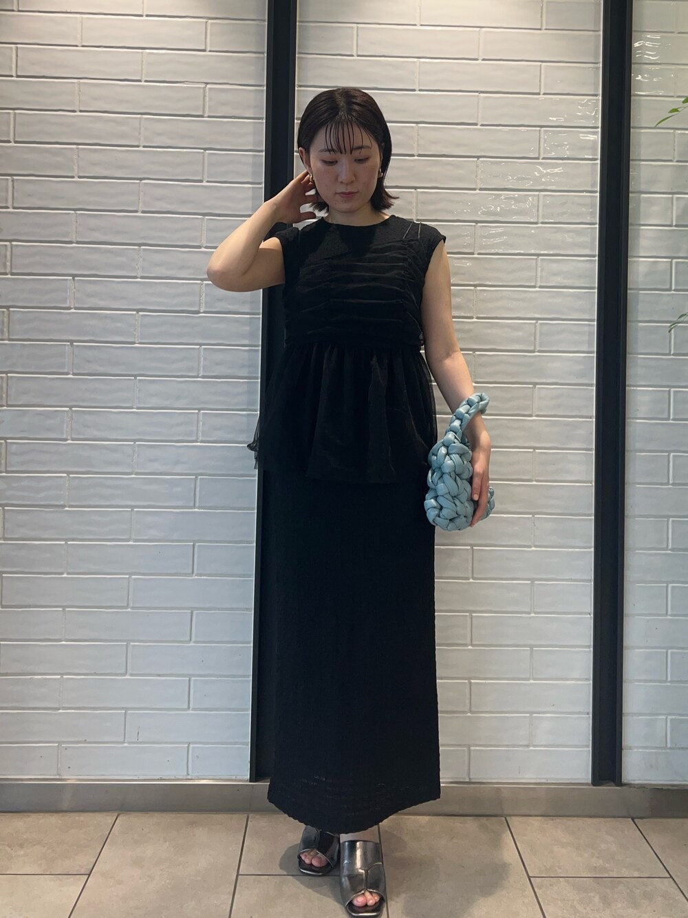 その他のサンダル、ブラック系のワンピース、ブルー系のハンドバッグを着用したレディースの夏コーディネートの1枚目の写真