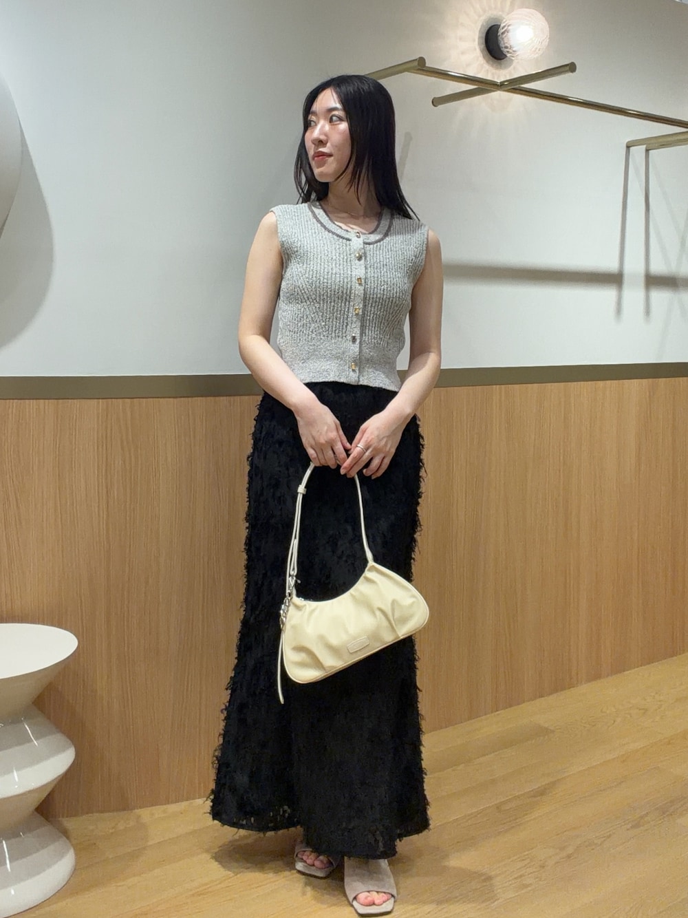 ブラック系のスカート、ベージュ系のニット/セーター、ベージュ系のサンダルを着用したレディースの春コーディネートの1枚目の写真