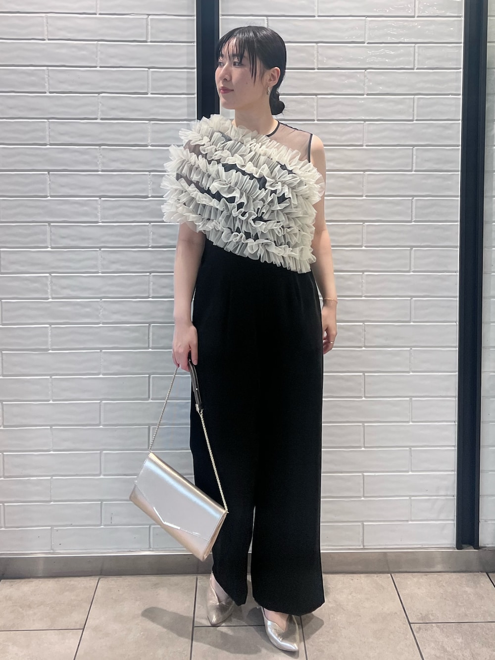 その他のパンツドレス、ゴールド系のパンプス、ゴールド系のクラッチバッグを着用したレディースの春コーディネートの1枚目の写真