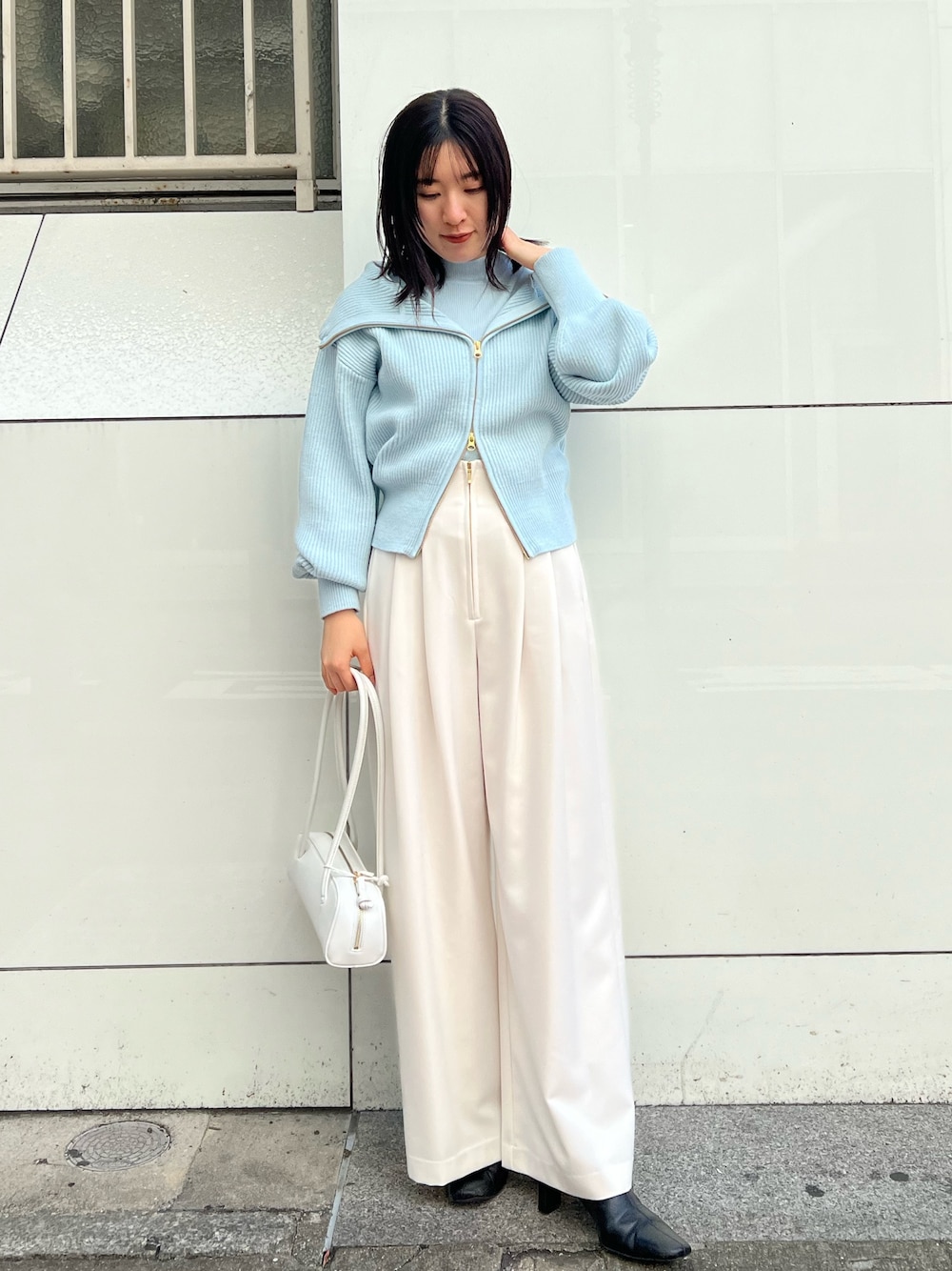 ホワイト系のショルダーバッグ、ホワイト系のその他パンツ、ブルー系のニット/セーターを着用したレディースの秋コーディネートの1枚目の写真