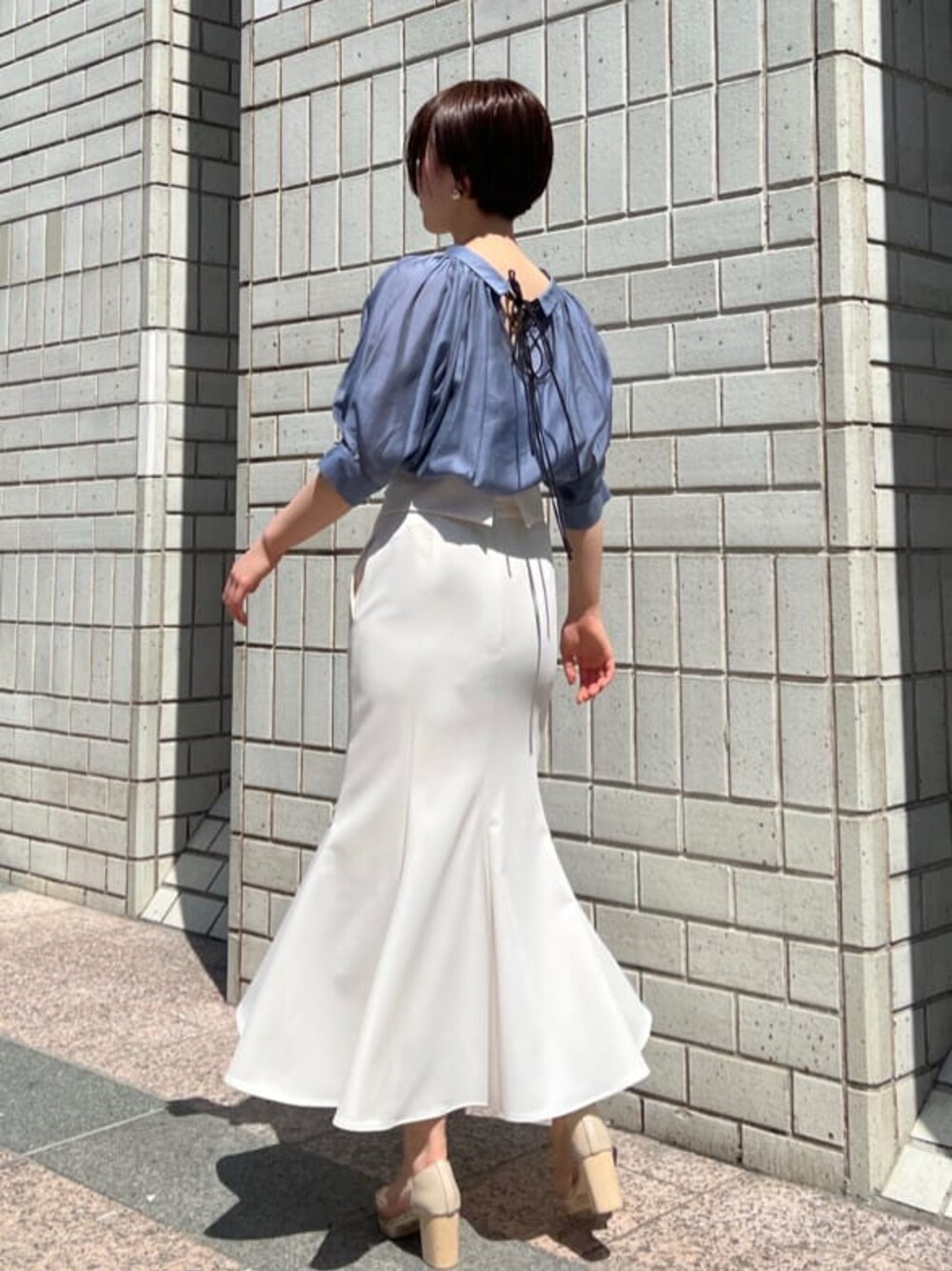 ホワイト系のスカート、その他のパンプス、ブルー系のシャツ/ブラウスを着用したレディースの春コーディネートの1枚目の写真