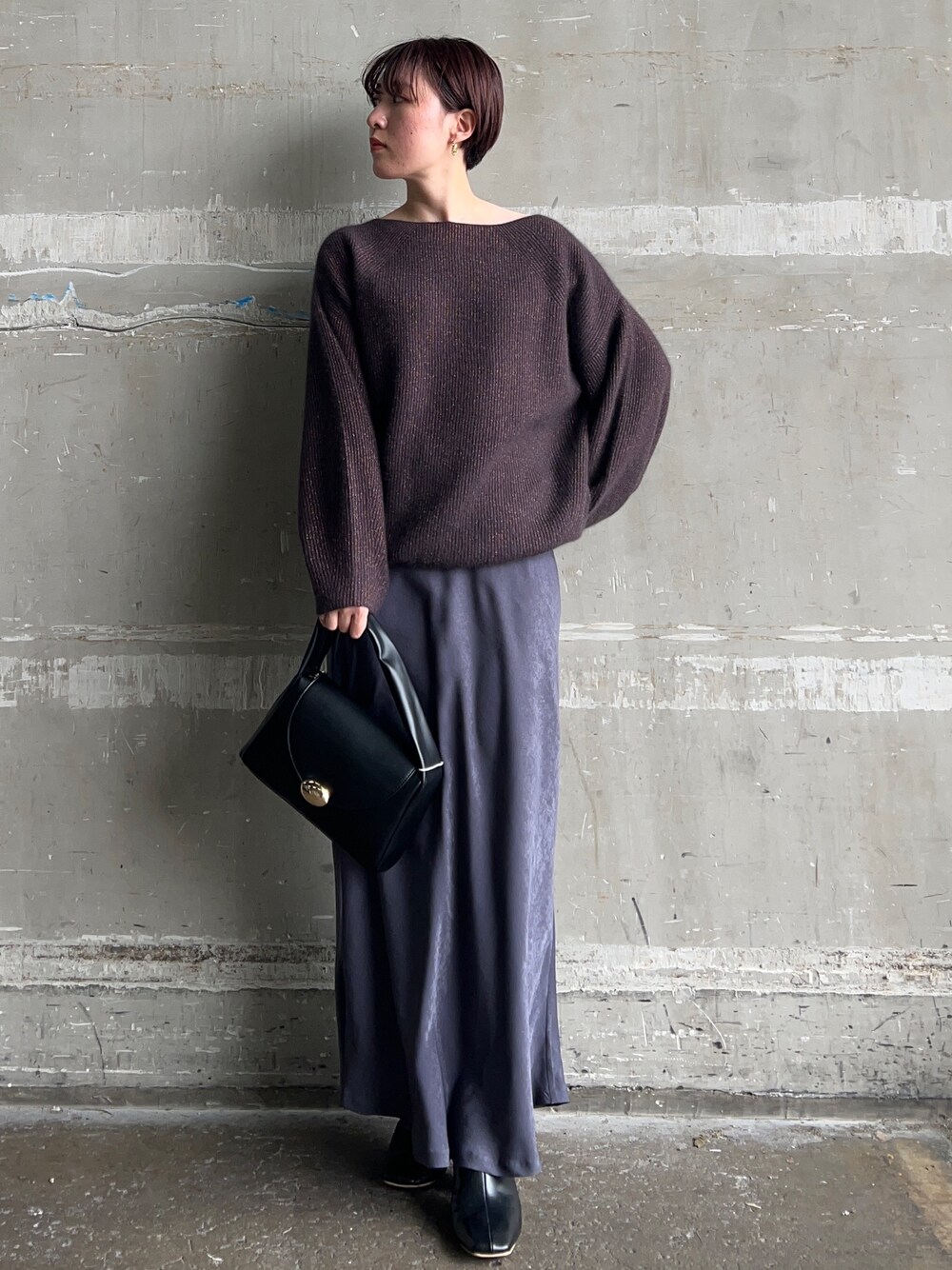 ブラック系のブーツ、グレー系のスカート、ブラウン系のニット/セーターを着用したレディースの秋コーディネートの1枚目の写真