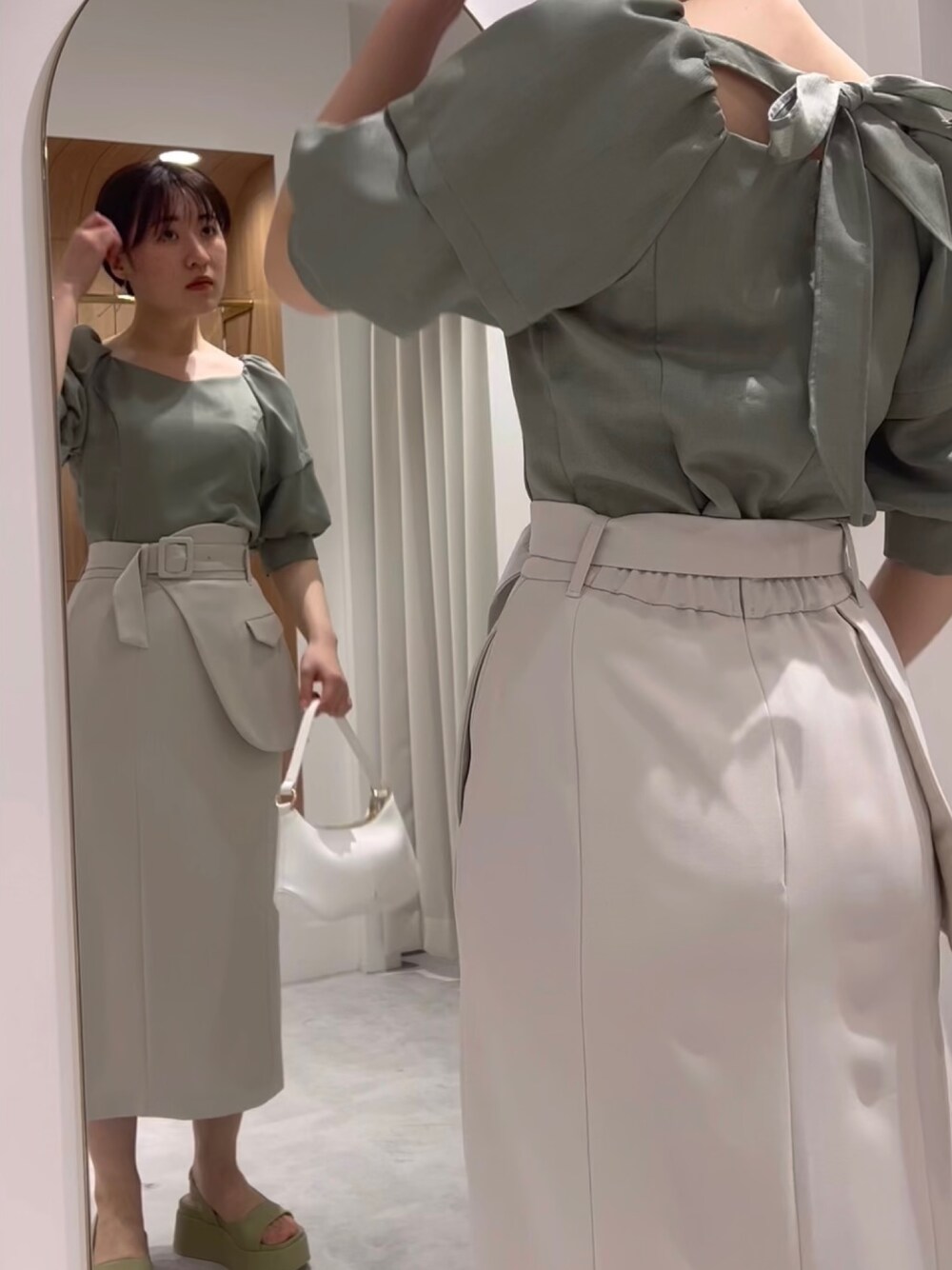 ホワイト系のハンドバッグ、ベージュ系のサンダル、グリーン系のシャツ/ブラウスを着用したレディースの春コーディネートの1枚目の写真