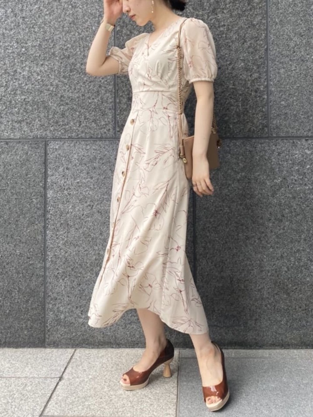 ブラウン系のパンプス、ベージュ系のショルダーバッグ、ホワイト系のワンピースを着用したレディースの夏コーディネートの1枚目の写真