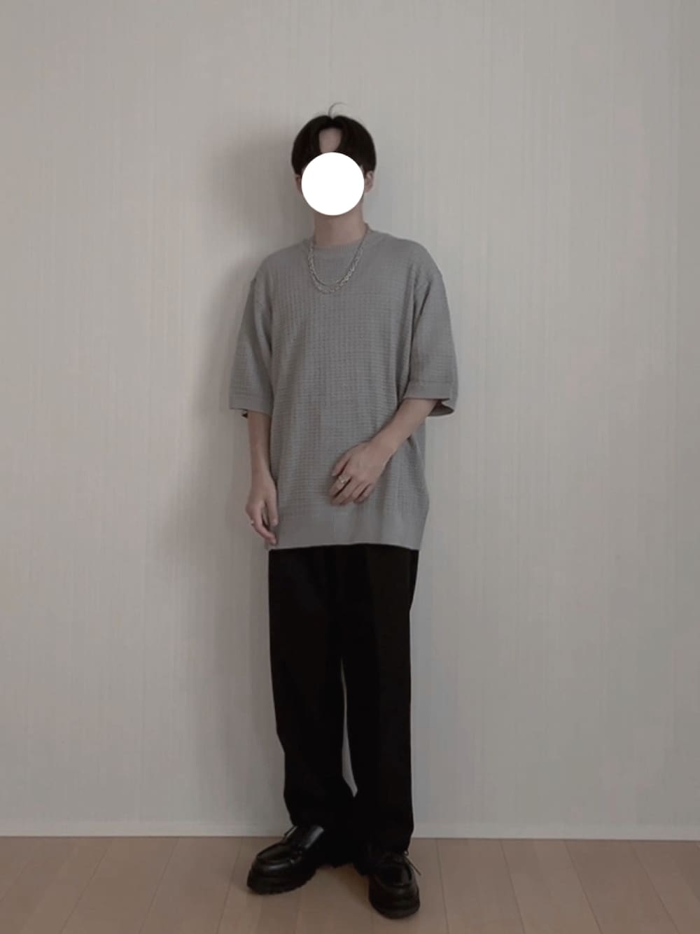 グレー系のニット/セーター、ブラック系のスラックス、ブラック系のモカシン/デッキシューズを着用したメンズの夏コーディネートの1枚目の写真