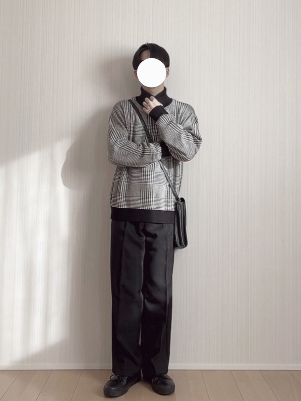 ブラック系のスラックス、ブラック系のスニーカー、ブラック系のニット/セーターを着用したメンズの冬コーディネートの1枚目の写真