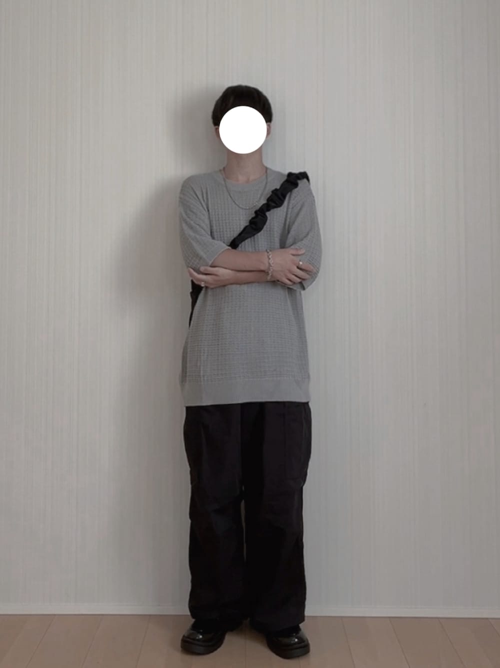 グレー系のニット/セーター、ブラック系のカーゴパンツ、ブラック系のローファーを着用したメンズの夏コーディネートの1枚目の写真