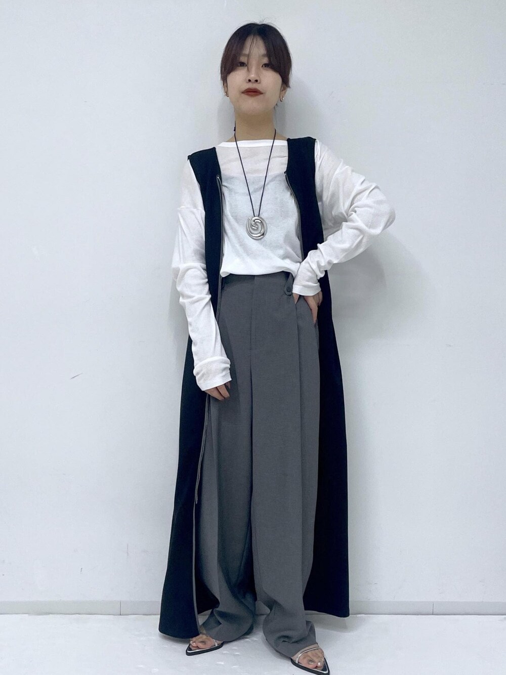 シルバー系のサンダル、ブラック系のワンピース、ホワイト系のTシャツ/カットソーを着用したレディースの春コーディネートの1枚目の写真