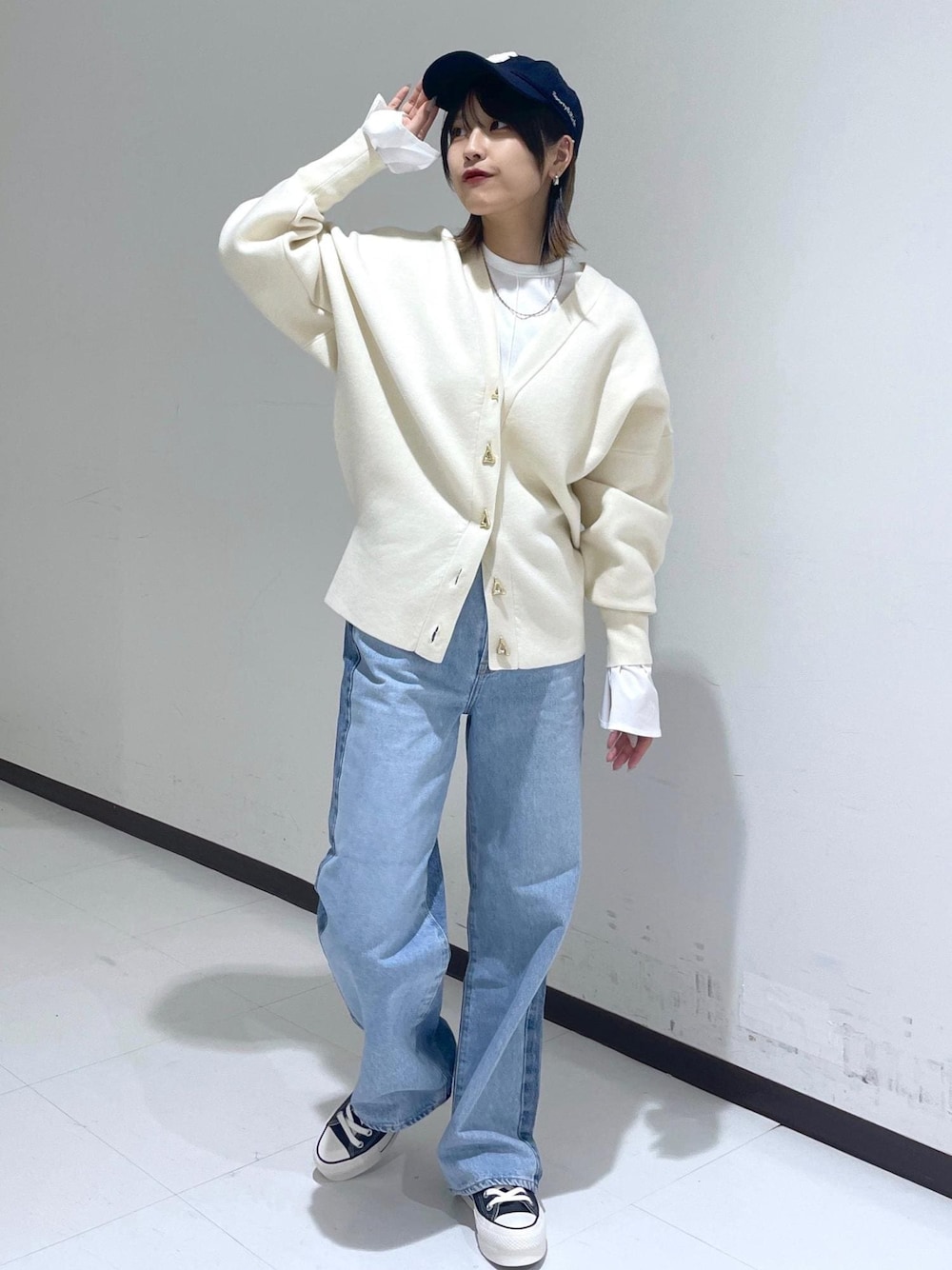 ホワイト系のカーディガン/ボレロ、ブルー系のデニムパンツ、ホワイト系のTシャツ/カットソーを着用したレディースの冬コーディネートの1枚目の写真