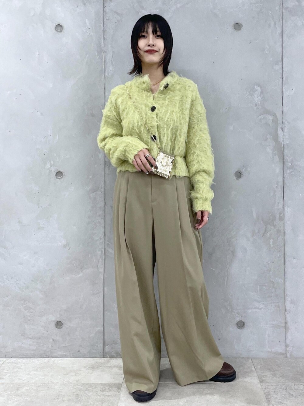 グリーン系のカーディガン/ボレロ、グリーン系のスラックス、ブラウン系のローファーを着用したレディースの秋コーディネートの1枚目の写真