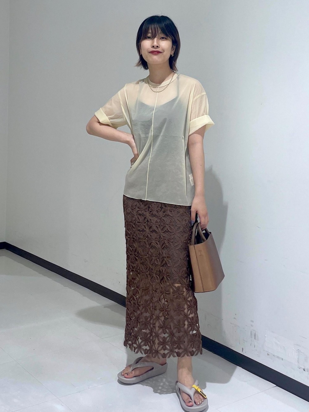 グレー系のサンダル、ベージュ系のTシャツ/カットソー、その他のハンドバッグを着用したレディースの夏コーディネートの1枚目の写真