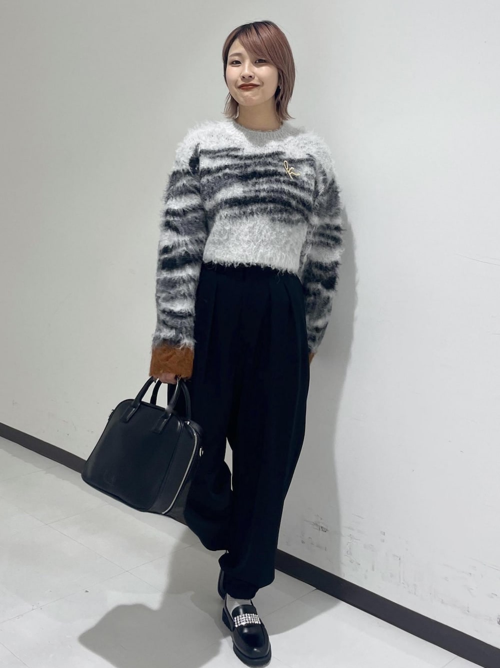 ブラック系のボストンバッグ、ブラック系のローファーを着用したレディースの冬コーディネートの1枚目の写真