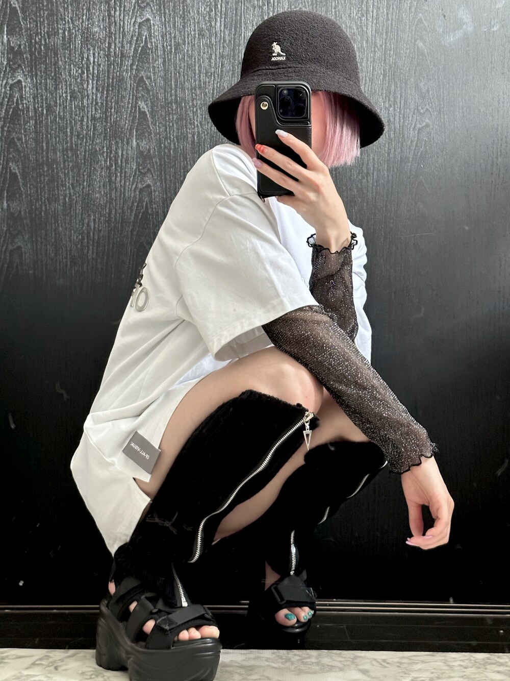 ブラック系のトップス、ブラック系のサンダル、ホワイト系のTシャツ/カットソーを着用したレディースの夏コーディネートの1枚目の写真