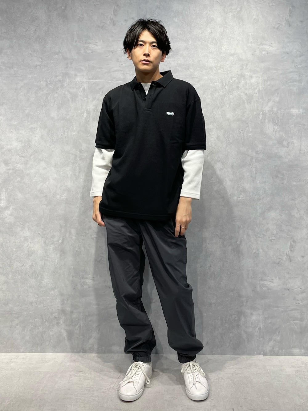 グレー系のスウェットパンツ、ブラック系のポロシャツ、ホワイト系のTシャツ/カットソーを着用したメンズの春コーディネートの1枚目の写真