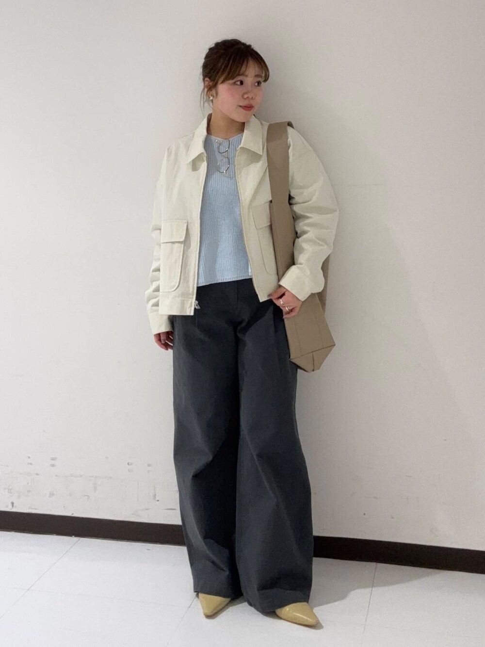 ベージュ系のパンプス、グレー系のその他パンツ、ホワイト系のブルゾンを着用したレディースの冬コーディネートの1枚目の写真