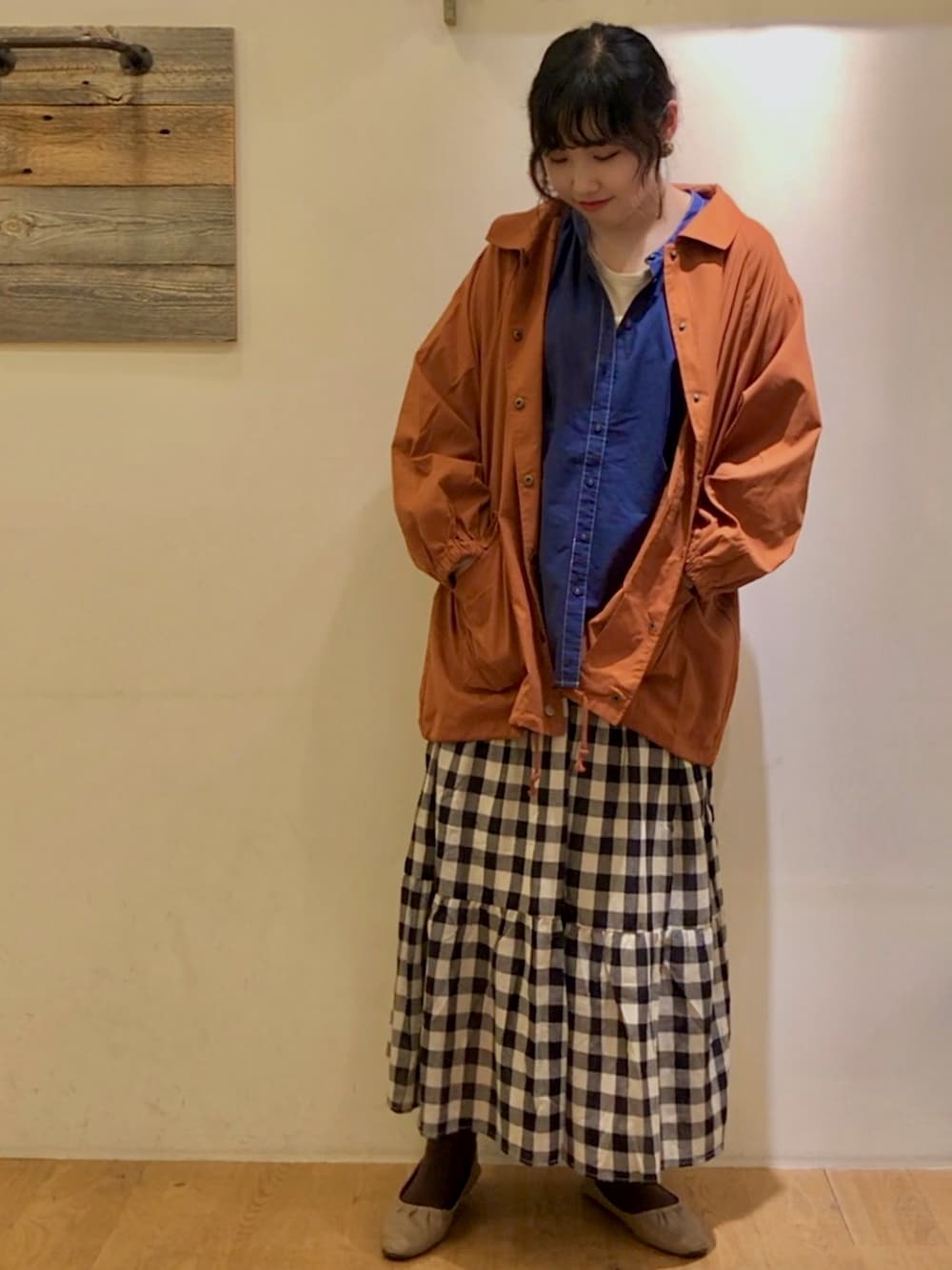 ホワイト系のスカート、ブラウン系のブルゾン、ブルー系のシャツ/ブラウスを着用したレディースの秋コーディネートの1枚目の写真