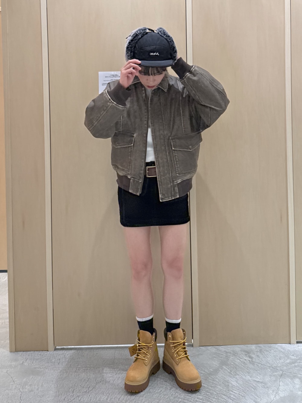 ブラウン系のブルゾン、ホワイト系のTシャツ/カットソー、ブラック系のデニムスカートを着用したレディースの秋コーディネートの1枚目の写真