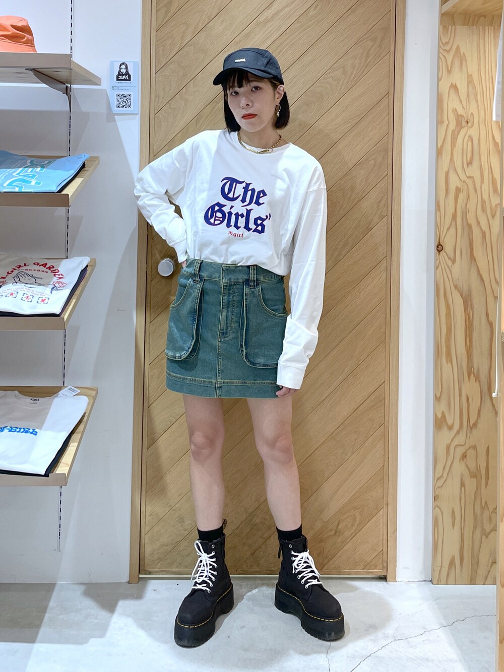 ホワイト系のTシャツ/カットソー、ブルー系のスカート、ブラック系のキャップを着用したレディースの秋コーディネートの1枚目の写真