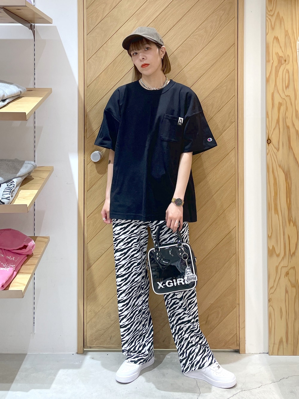 ブラック系のTシャツ/カットソー、ブラック系のショルダーバッグ、ホワイト系のその他パンツを着用したレディースの春コーディネートの1枚目の写真