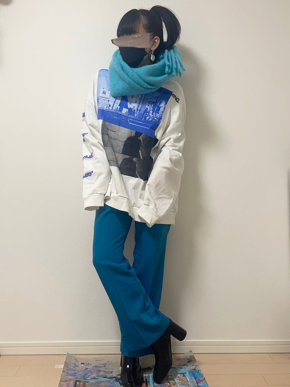 ブルー系のスラックス、ホワイト系のスウェット、ブラック系のブーツを着用したレディースの冬コーディネートの1枚目の写真