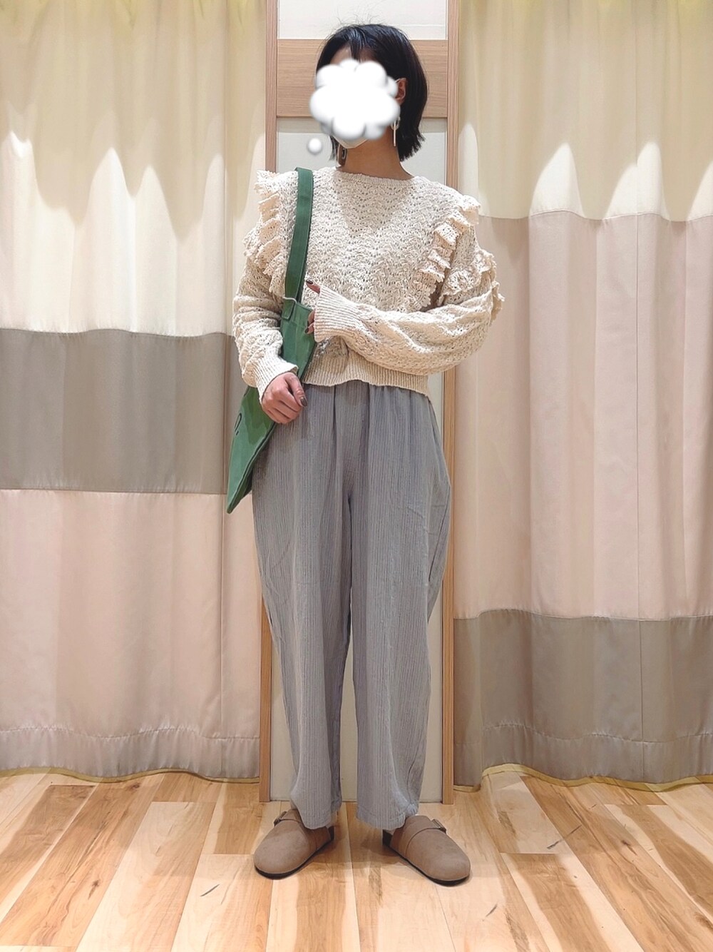 ブルー系のその他パンツ、ホワイト系のニット/セーター、グリーン系のトートバッグを着用したレディースの冬コーディネートの1枚目の写真