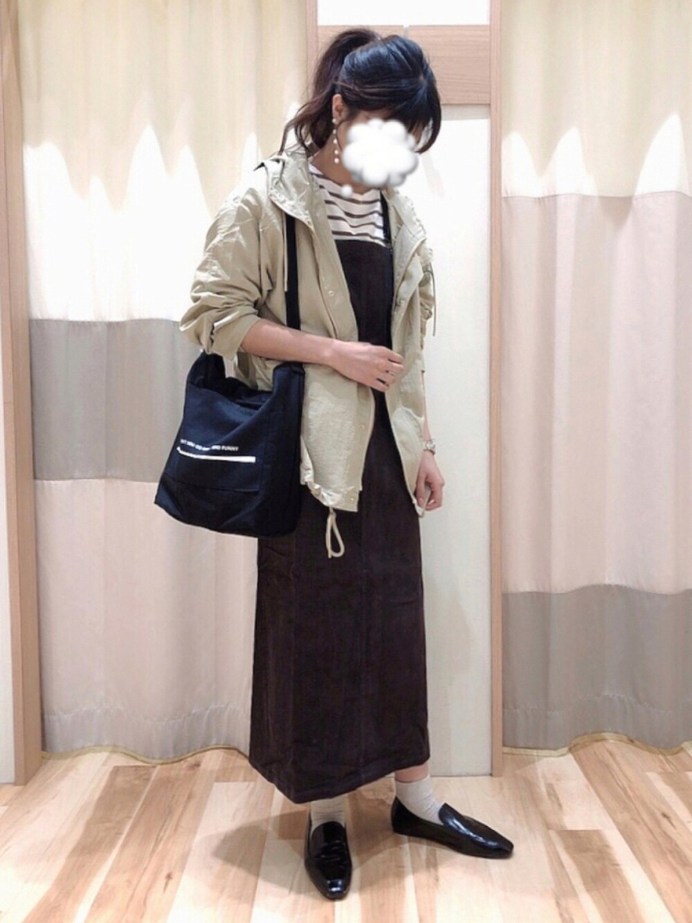 グレー系のジャンパースカート、ベージュ系のパーカーを着用したレディースの秋コーディネートの1枚目の写真