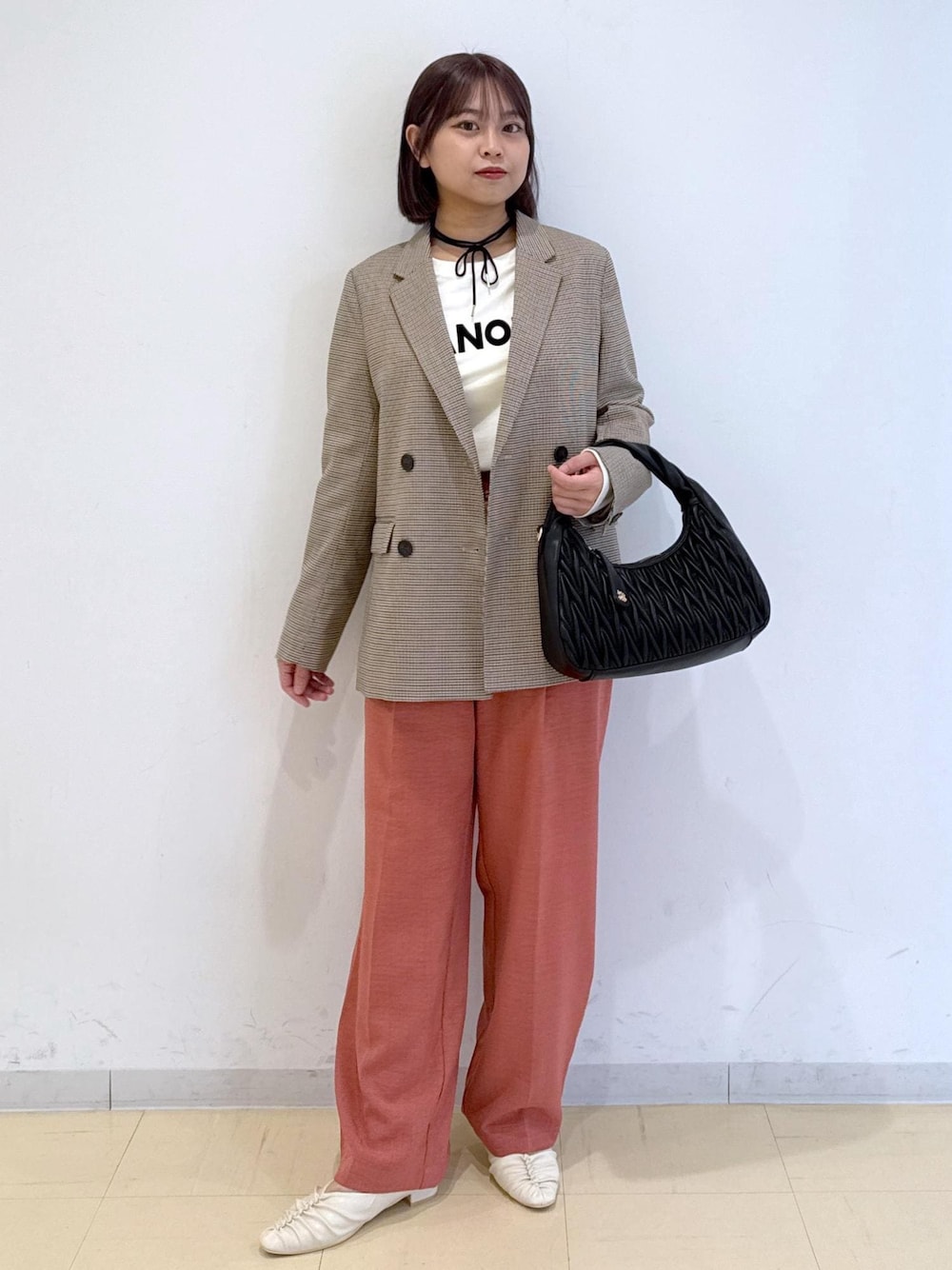 オレンジ系のスラックス、ベージュ系のテーラードジャケット、ホワイト系のTシャツ/カットソーを着用したレディースの秋コーディネートの1枚目の写真