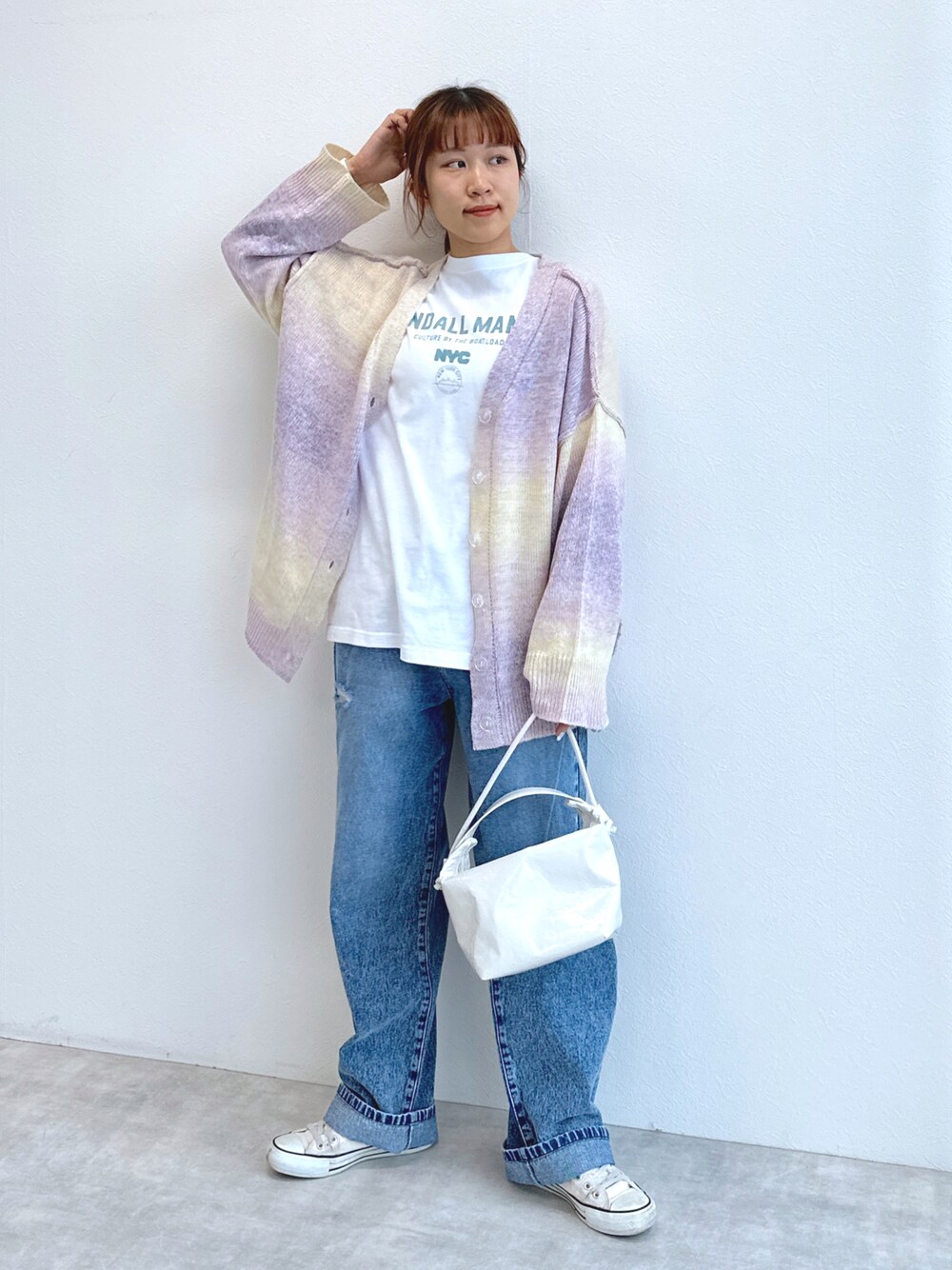 ブルー系のデニムパンツ、ホワイト系のTシャツ/カットソー、ピンク系のカーディガン/ボレロを着用したレディースの冬コーディネートの1枚目の写真