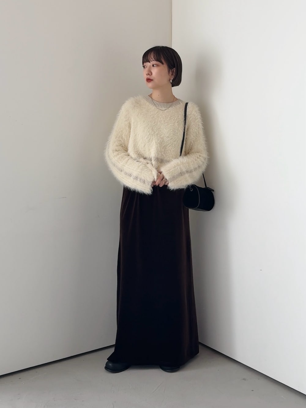 ホワイト系のニット/セーター、ブラウン系のスカートを着用したレディースの秋コーディネートの1枚目の写真